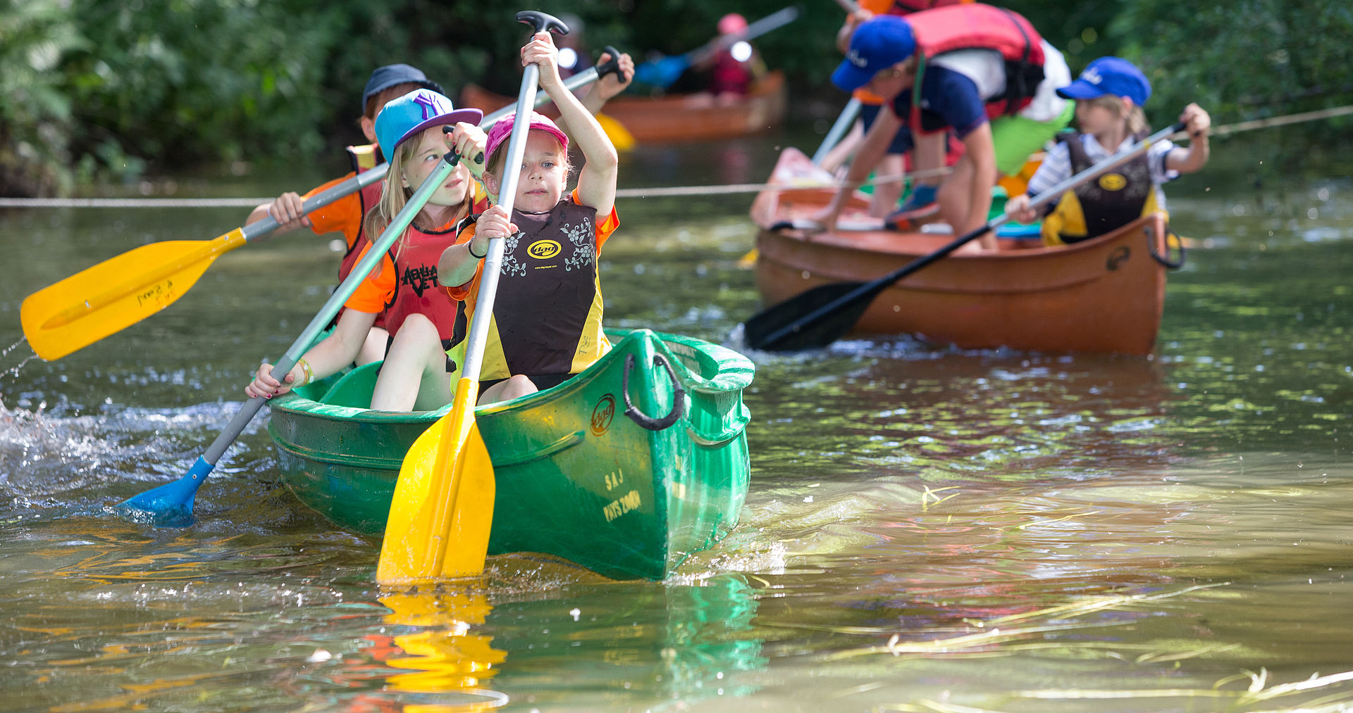 Enfants en plein effort dans 2 canoes